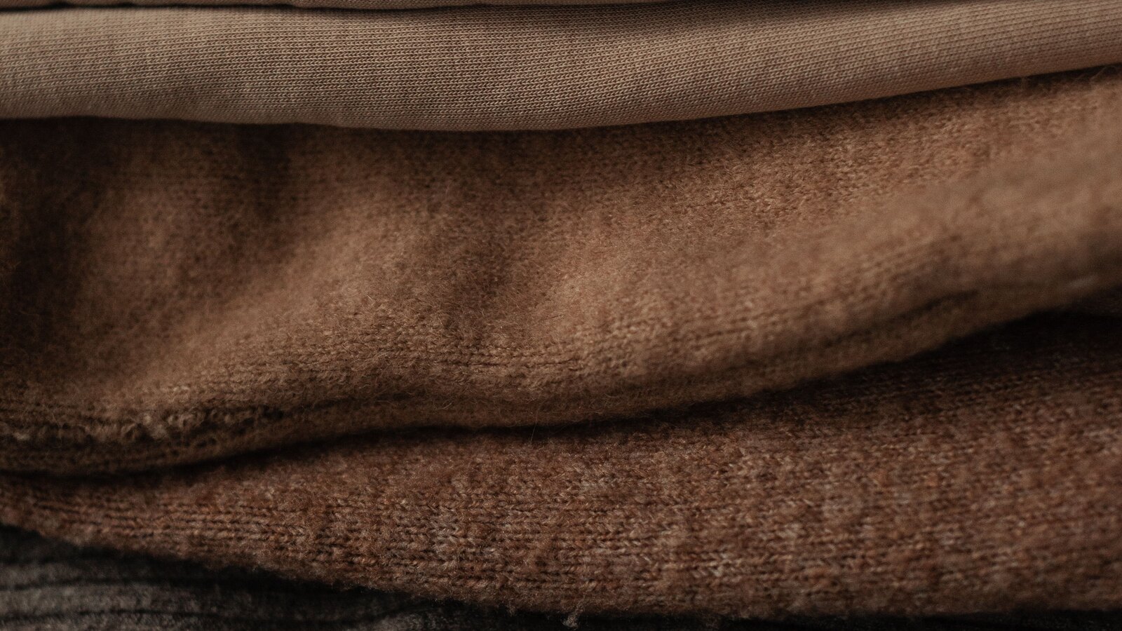 Neutral clothing folded on shelves