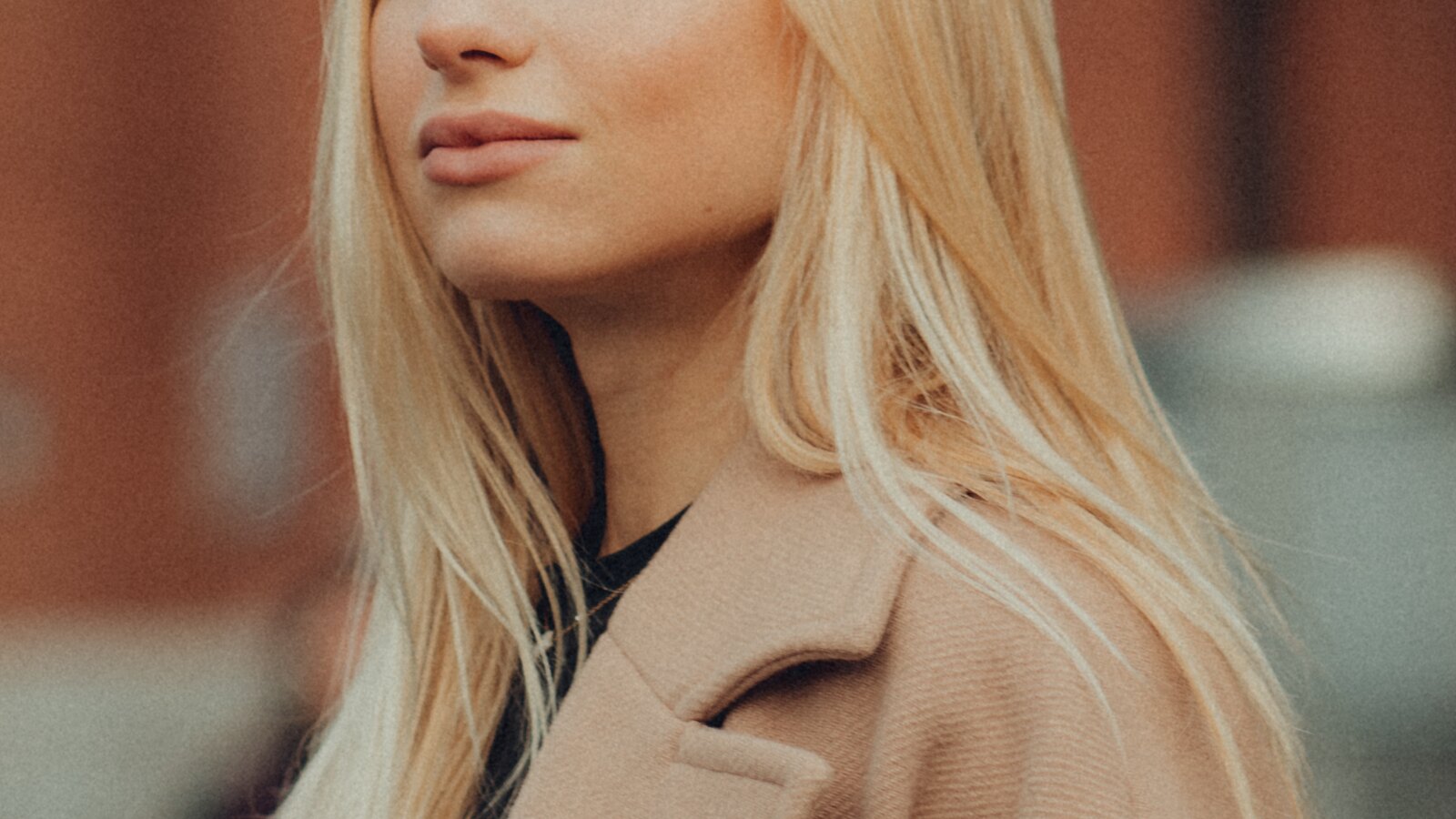 Woman in a camel coat and neutral outfit in soft light